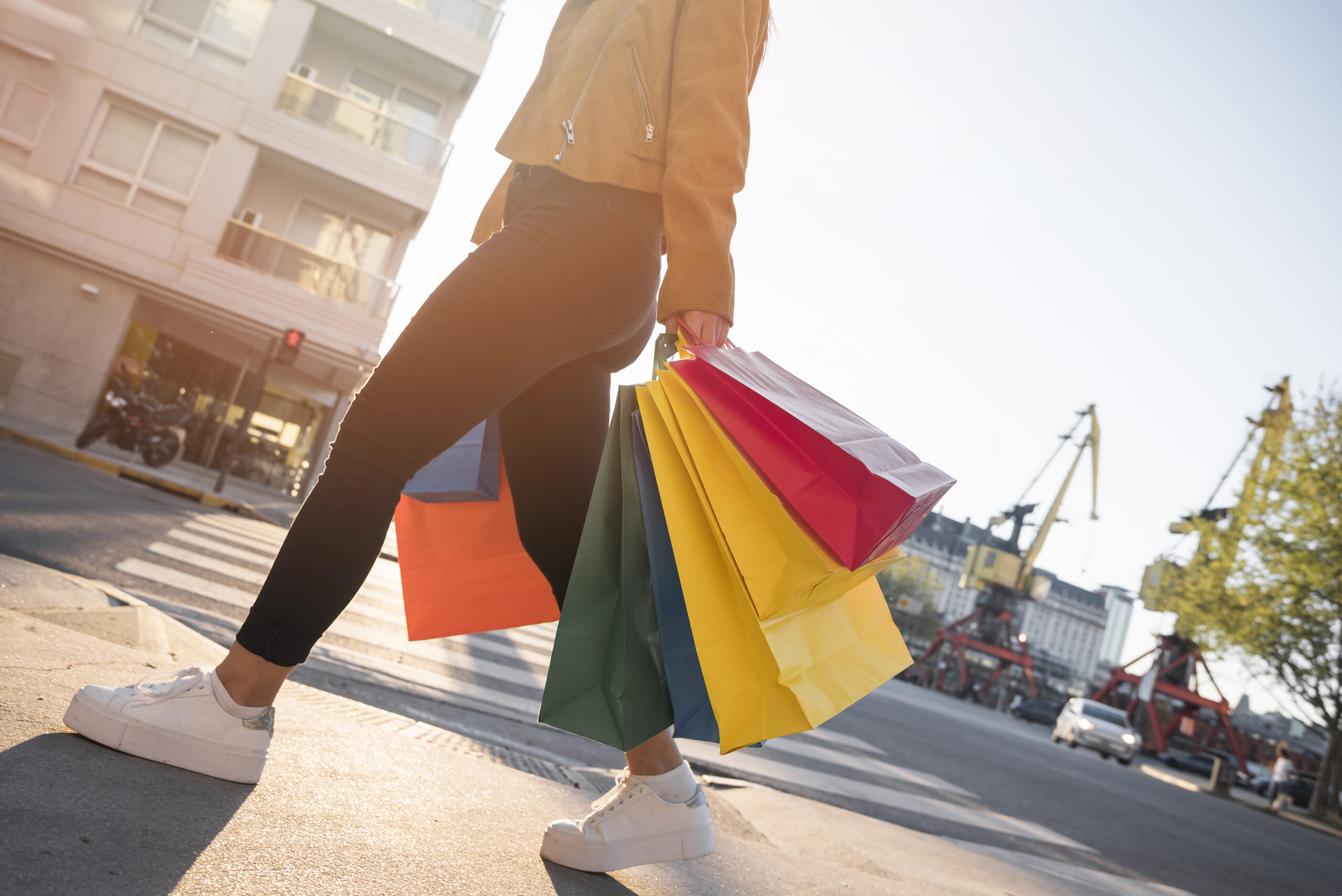 Joven con bolsas de compras en la calle